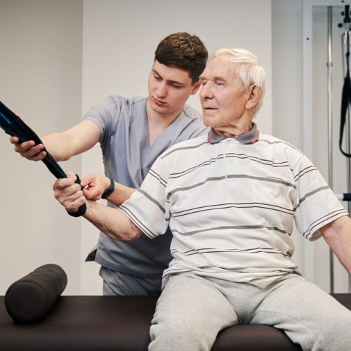senior patient on couch pulling resistance band